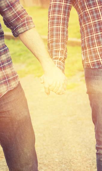 Closeup of two men holding hands