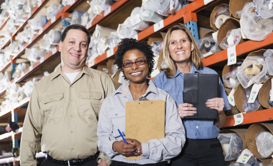 Three workers standing in a stock room
