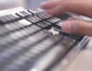 A hand typing on a keyboard