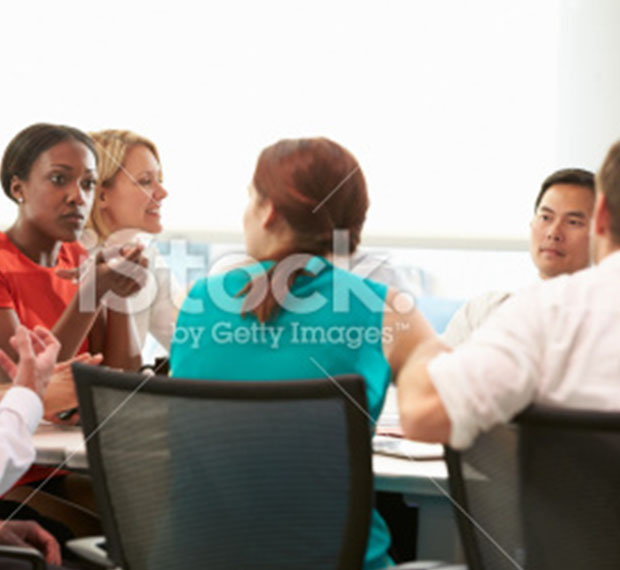 Group of business people meeting around boardroom table