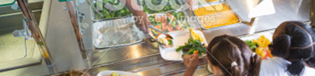 cafeteria workers serving healthy meals to children